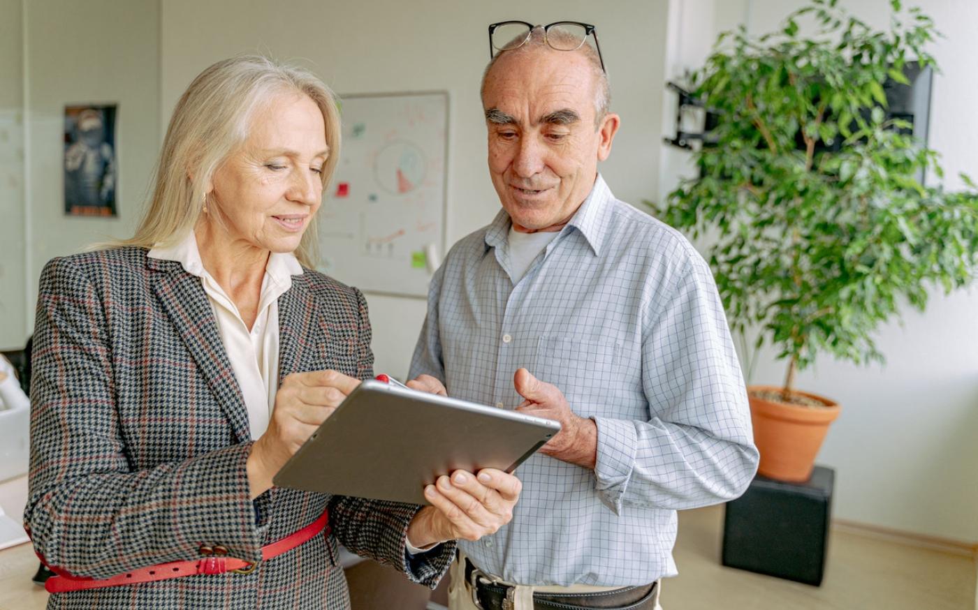 Professionally dressed man and woman looking at a tablet