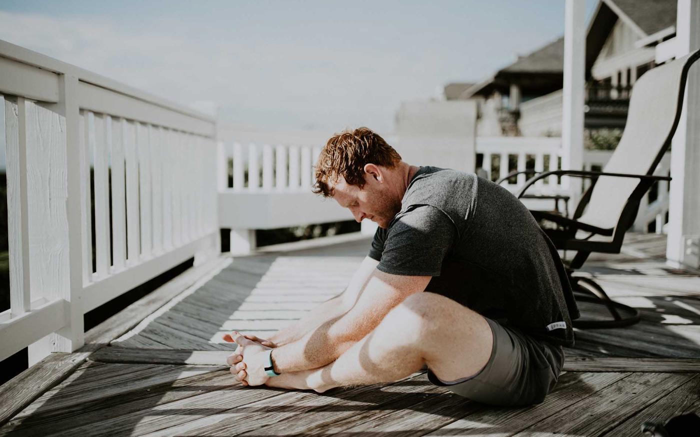 Male stretching on patio.
